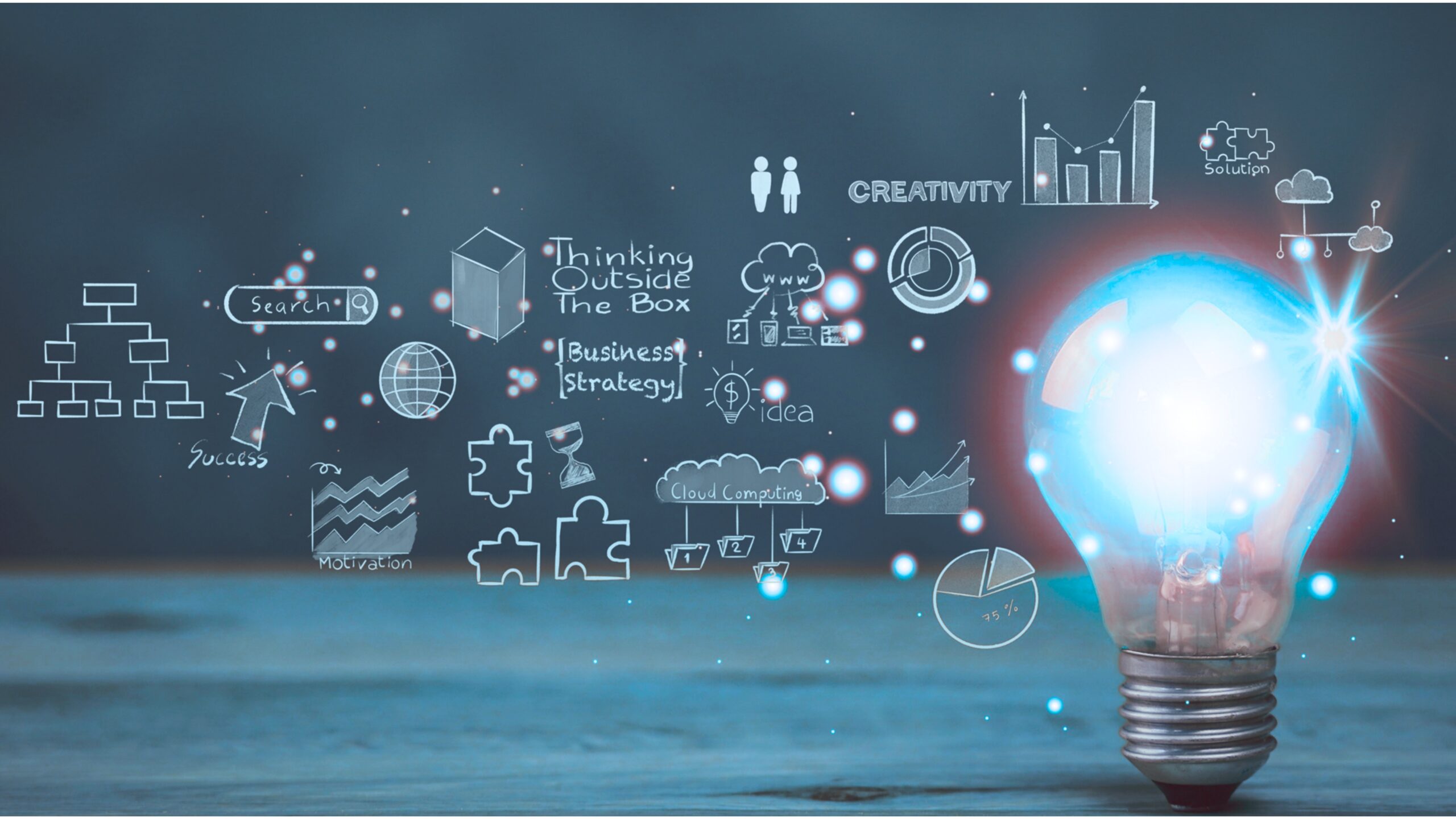 Una lampadina incandescente si trova su una superficie di legno, circondata da ghirigori legati al business e alle idee, come grafici, diagrammi, pezzi di puzzle e testi come Problem Solving, Thinking Outside The Box e CREATIVITY su uno sfondo scuro.