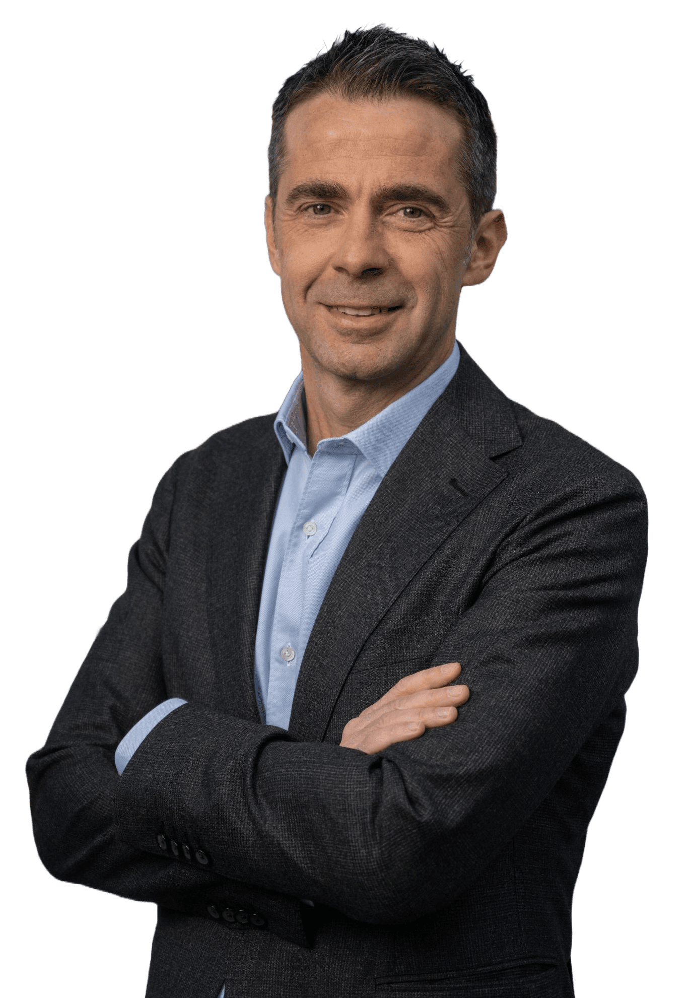 Un uomo che indossa una giacca scura e una camicia azzurra sta in piedi con le braccia incrociate, sorridendo con sicurezza alla telecamera su uno sfondo bianco, incarnando il Lean Thinking in vera maniera italiana.